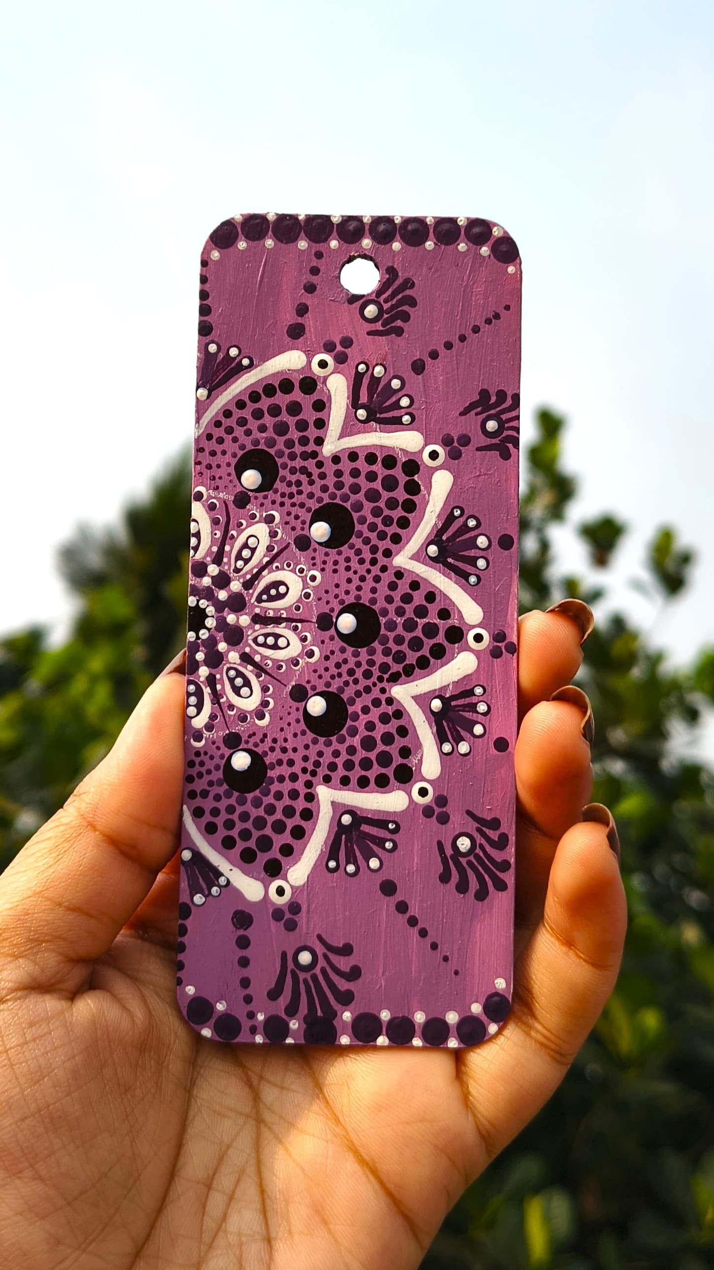 Purple mandala with mauve and white concentric dot patterns in radial symmetry