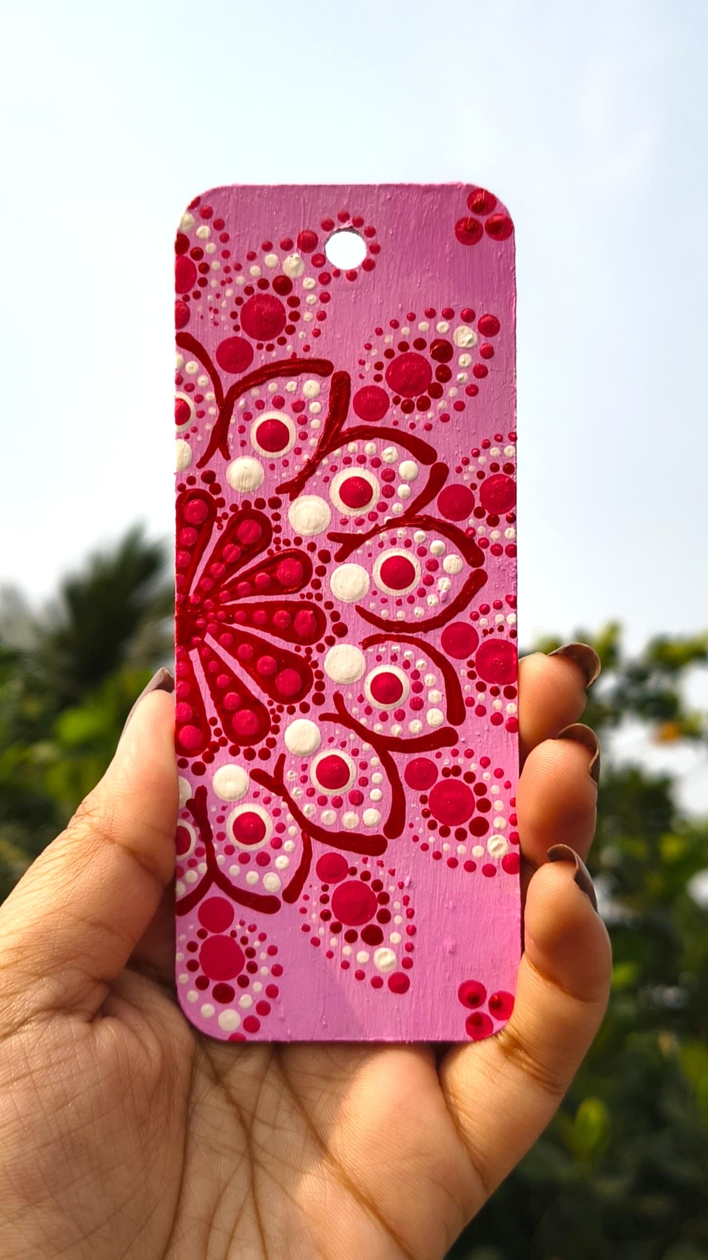 Pink mandala with red and white concentric dot patterns in radial symmetry