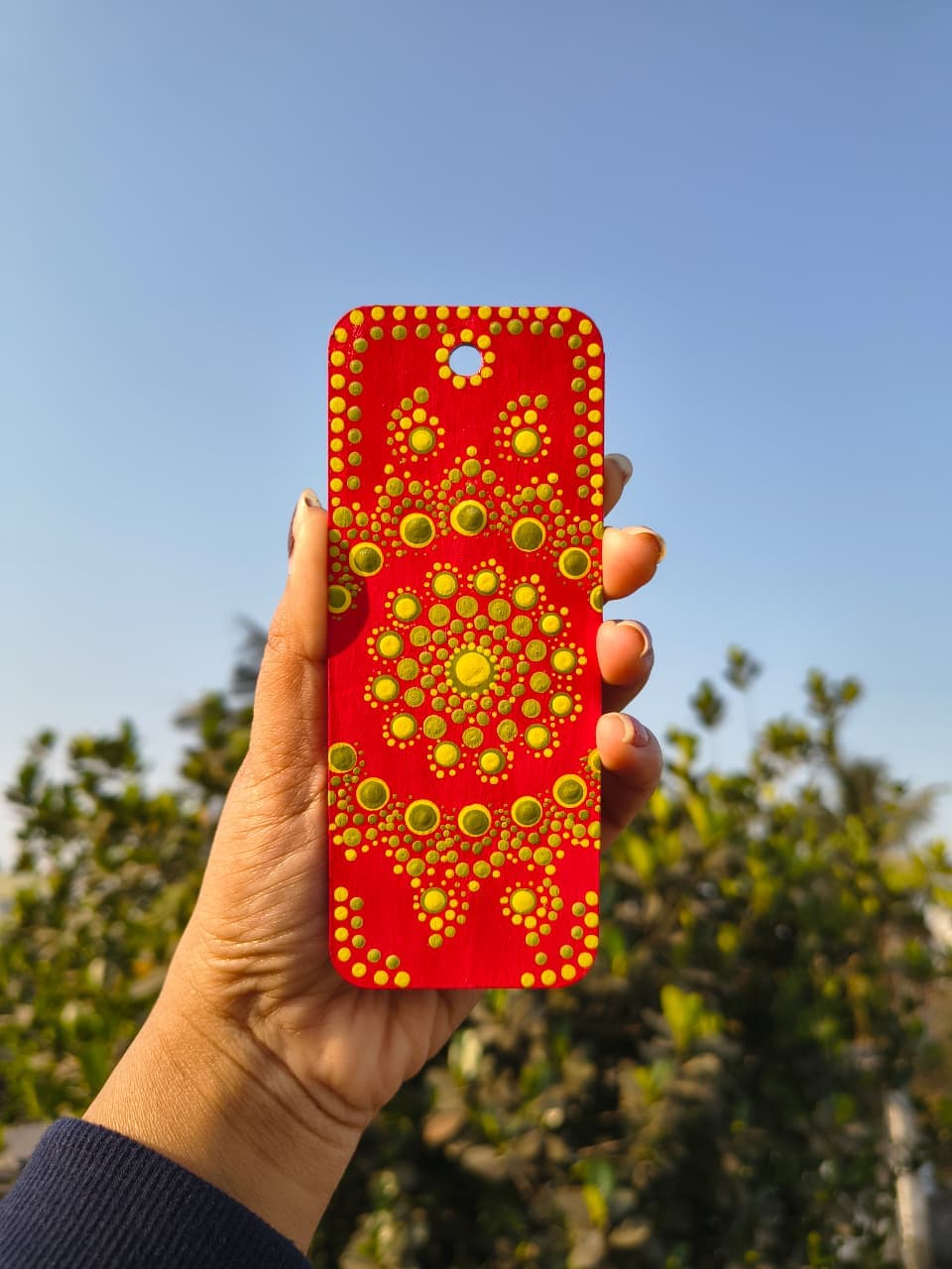 Red mandala with concentric golden dot patterns in radial symmetry