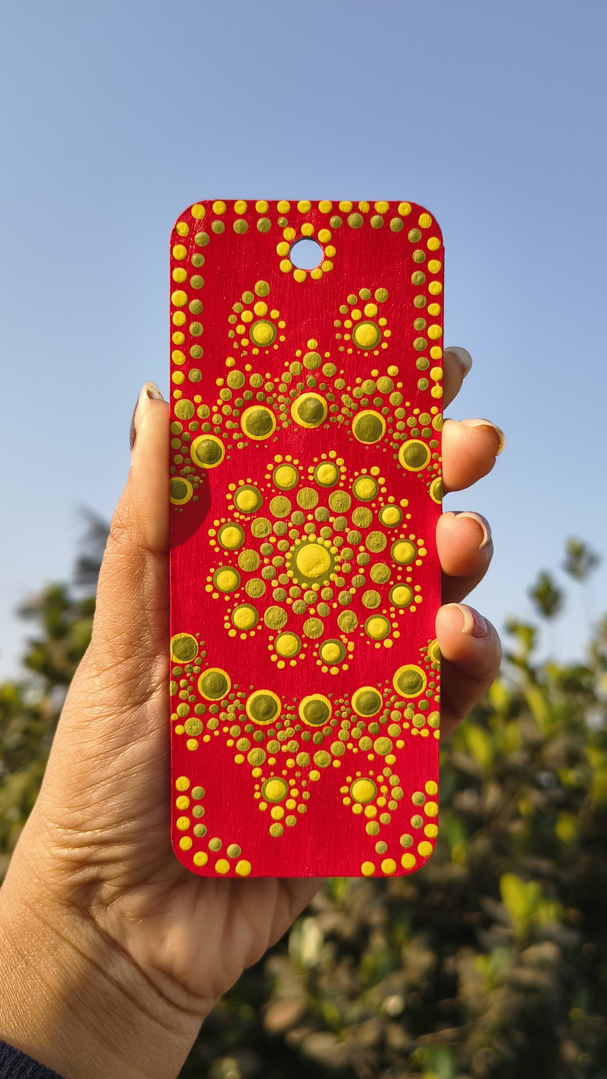Red mandala with concentric golden dot patterns in radial symmetry